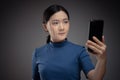 Asian woman scans face by smart phone using facial recognition system Royalty Free Stock Photo