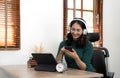 Asian woman school student wear headphones hold smartphone using distance learning mobile app online watching video Royalty Free Stock Photo