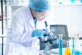 Asian woman scientist, researcher, technician, or student conducted research or experiment by using microscope in laboratory Royalty Free Stock Photo