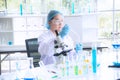 Asian woman scientist, researcher, technician, or student conducted research or experiment by using microscope in laboratory Royalty Free Stock Photo