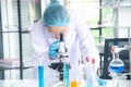 Asian woman scientist, researcher, technician, or student conducted research or experiment by using microscope in laboratory Royalty Free Stock Photo