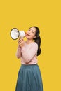 Asian woman screaming while holding megaphone with two hands making announcement Royalty Free Stock Photo