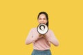 Asian woman screaming while holding megaphone with two hands making announcement Royalty Free Stock Photo