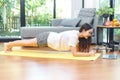 Asian woman searching and  watching online tutorials videos on laptop for doing yoga plank, fitness exercise training at home Royalty Free Stock Photo