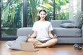 Asian woman searching and  watching online tutorials videos on laptop for doing yoga plank, fitness exercise training at home Royalty Free Stock Photo