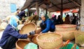 Asian woman selling bamboo basket at market