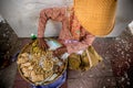 Asian woman selling peanuts on street