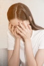 Asian woman with severe migraine headache holding hands to head in a room. Royalty Free Stock Photo