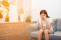 Asian woman with severe migraine headache holding hands to head in a room. Royalty Free Stock Photo