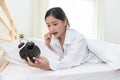 Asian woman shocked when wake up late by forget to setting alarm clock at night and having meeting appointment and working in Royalty Free Stock Photo