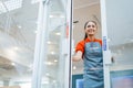 Asian woman shop assistant smiles happily when opening the door