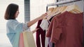 Asian woman shopping clothes. Shopper looking at clothing on the rail indoors in clothing store. Beautiful happy smiling asian Royalty Free Stock Photo