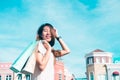 Asian woman shopping an outdoor flea market with a background of pastel buildings. Royalty Free Stock Photo