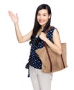 Asian woman with shoulder bag and hand present something