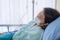 Asian woman is sick has a high fever, sneezing, is recuperating in the patient`s dress lay on the patient bed in the hospital wit