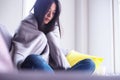 Asian woman is sick on the sofa inside the house. With chills, fever, suffering from discomfort Royalty Free Stock Photo