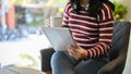 Asian woman sipping coffee and using tablet while relaxing in the coffees shop Royalty Free Stock Photo