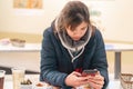 Asian woman sitting in a Bar with draft beer and snack on the table looking at her mobile phone Royalty Free Stock Photo