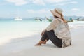 Asian woman sitting on the beach looking at the amazing sea and enjoying with beautiful nature in her vacation. Royalty Free Stock Photo