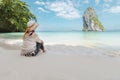 Asian woman sitting on the beach looking at the amazing sea and enjoying with beautiful nature in her vacation. Royalty Free Stock Photo