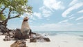 Asian woman sitting on the beach looking at the amazing sea and enjoying with beautiful nature in her vacation. Royalty Free Stock Photo