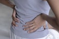 Asian woman sitting on bed and suffering from back pain. Royalty Free Stock Photo