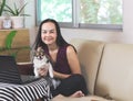 Asian woman sitting on couch in living room with  computer notebook  holding  Chihuahua dog looking and smiling at camera , work Royalty Free Stock Photo