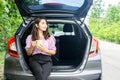 Asian woman sitting at her hatchback car enjoy drinking coffee traveling alone on holidays Royalty Free Stock Photo