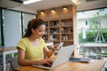 Asian woman sitting and holding credit card for online shopping by laptop and smart phone at home Royalty Free Stock Photo