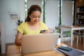 Asian woman sitting and holding credit card for online shopping by laptop and smart phone at home Royalty Free Stock Photo