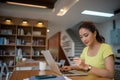 Asian woman sitting and holding credit card for online shopping by laptop and smart phone at home Royalty Free Stock Photo