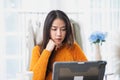 Asian woman sitting at home working at her desk with laptop computer. Royalty Free Stock Photo