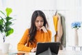 Asian woman sitting at home working at her desk with laptop computer. Royalty Free Stock Photo