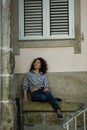 Asian woman sitting near the wall of the house in Porto Royalty Free Stock Photo