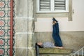 Asian woman sitting near the wall of the house in Porto Royalty Free Stock Photo