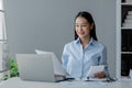 Asian woman sitting in startup company office, businesswoman, executive and investor in business and stocks, management of young Royalty Free Stock Photo