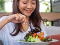 An Asian woman sitting at a table eating salmon salad for good health. diet and Clean food Royalty Free Stock Photo