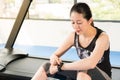 Asian woman sitting on treadmill. smartwatch check pulse rate Royalty Free Stock Photo