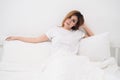 Asian woman sitting on white bed Royalty Free Stock Photo