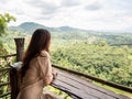 Asian woman sitting on wooden table in cafe with green mountain view. Nan, Thailand. Royalty Free Stock Photo