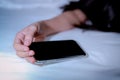 Asian woman sleeping in bed at home and hand holding mobile phone. Woman using smartphone in bedroom. Young woman addicted using
