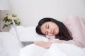Asian women are sleeping because they are tired of work from laptop computer at bedroom, concept lifestyle and work at home