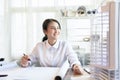 Asian woman smart architect look out the window to rest one\'s eyes or relax while working in light and bright office room,