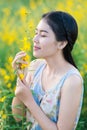 Asian woman smelling flowers.