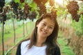 Asian woman Smile and Bunch of grapes in vineyard. Winery, wine