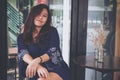 Asian woman with smiley face and feeling good sitting in coffee shop Royalty Free Stock Photo