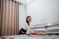 Asian woman smiling hotel maid smoothing a pillow on a bed Royalty Free Stock Photo