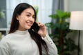 Asian woman smiling while talking on the phone in the living room Royalty Free Stock Photo