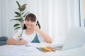 Asian woman smiling and thumbs up showing excellence, girl studying online at home Royalty Free Stock Photo