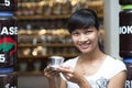 An asian woman smiling with a Vietnamese Coffee - Hot milk coffee with condensed milk in Vietnam style. Traditional Vietnamese dri